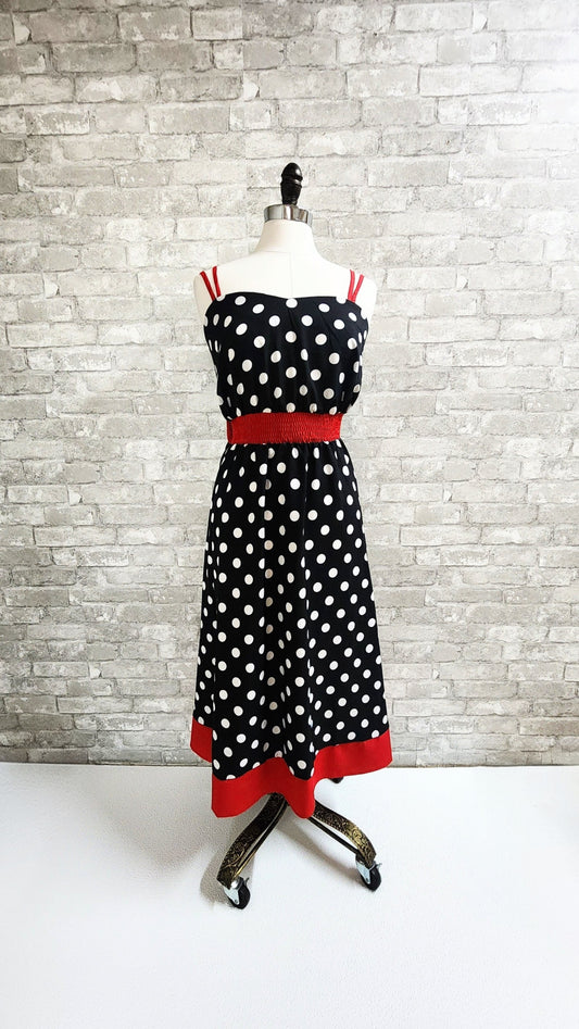 Polka dot dress with red accents on a mannequin against a brick wall at Hollyville clothing shop in South Milwaukee.