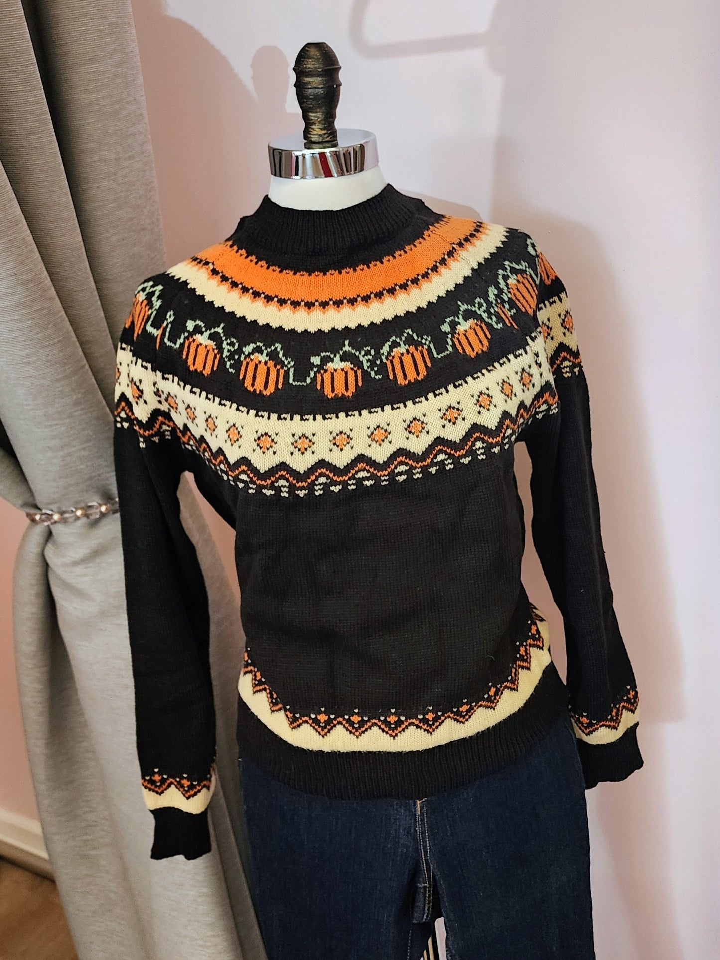 Black sweater with Halloween-themed pattern on a mannequin against a neutral background at Hollyville in South Milwaukee.