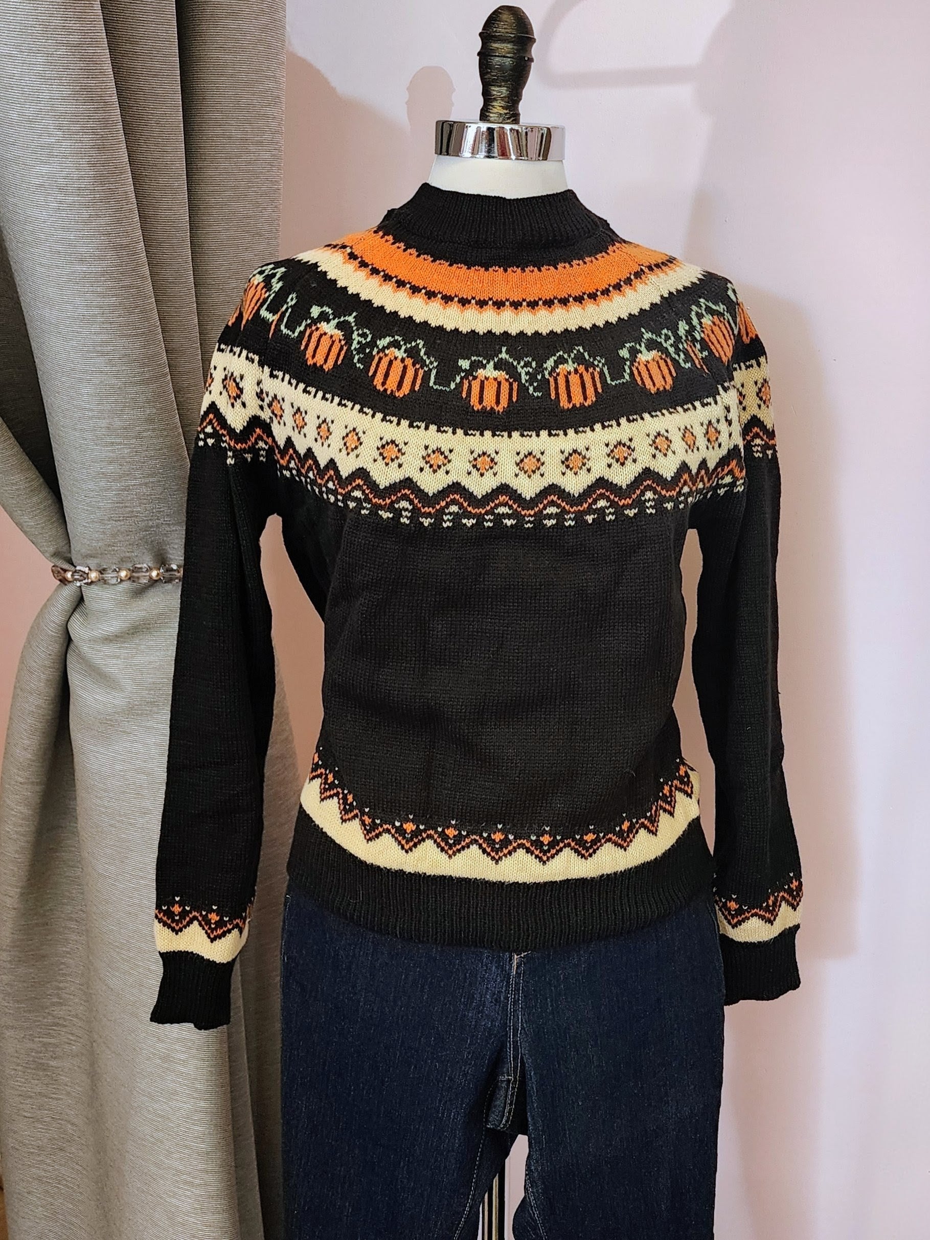 Black sweater with Halloween-themed pattern on a mannequin against a neutral background at Hollyville Pinup Boutique in South Milwaukee.