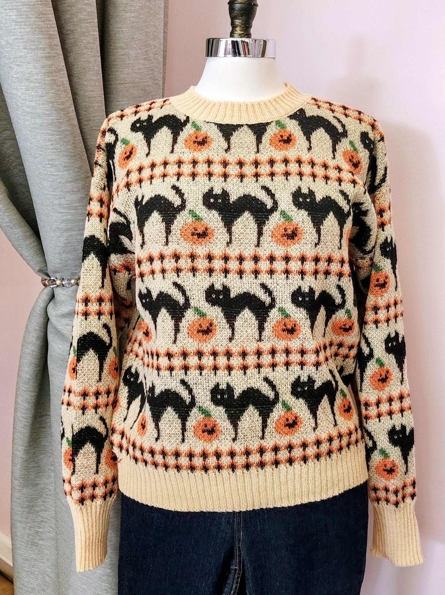 Sweater with black cat and pumpkin pattern on a mannequin against a neutral background at Hollyville clothing shop in South Milwaukee.