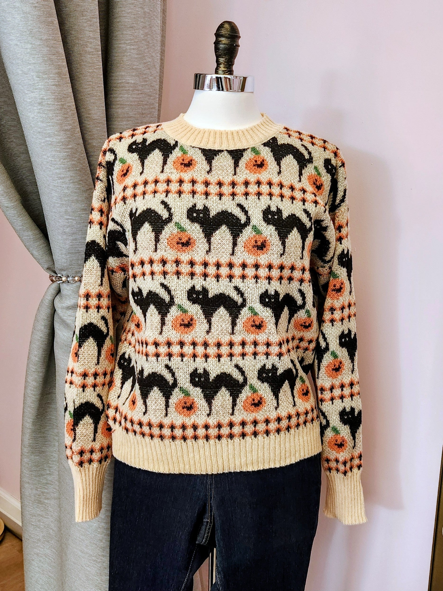 Sweater with black cat and pumpkin pattern on a mannequin against a background at Hollyville Pinup Boutique in South Milwaukee.