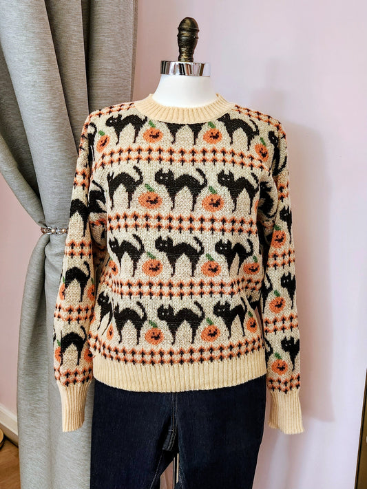 Sweater with black cat and pumpkin pattern on a mannequin against a background at Hollyville Pinup Boutique in South Milwaukee.