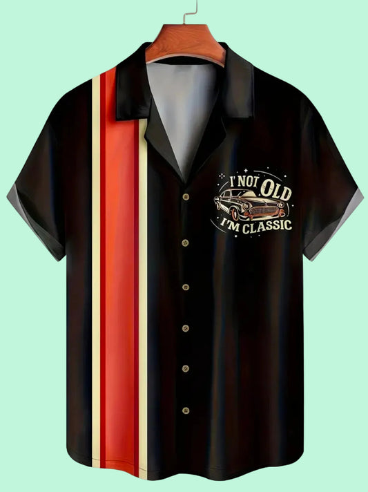 Black shirt with orange and beige striped sleeves on a hanger against a mint background